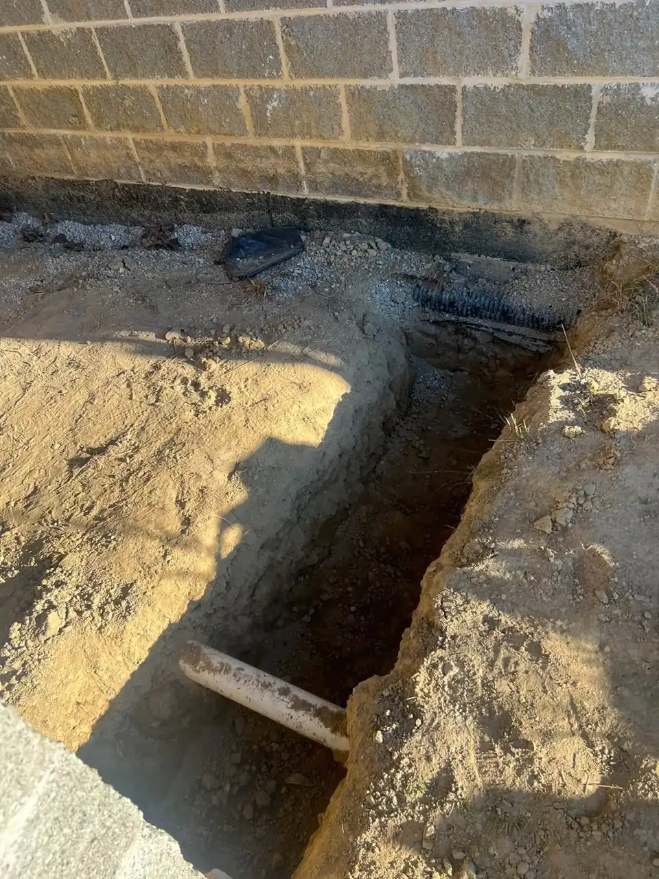 Deep structural footing excavation along a masonry foundation
