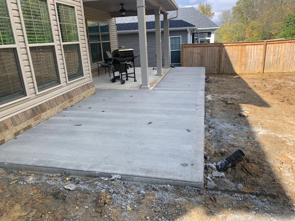 Broom-finished concrete patio beside a covered porch