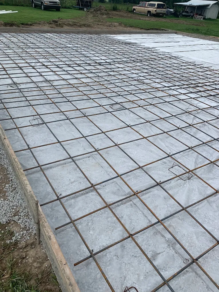 Wide foundation slab with rebar grid and vapor barrier before the pour
