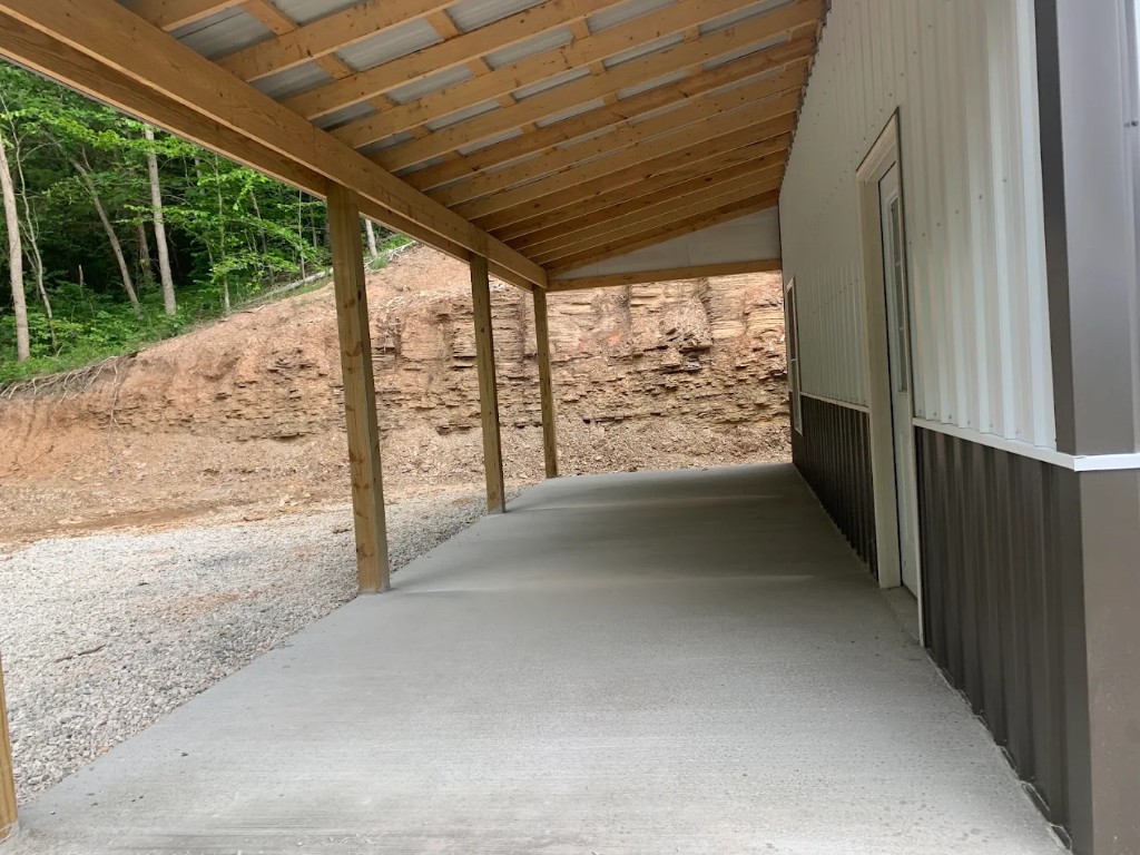 Concrete porch slab under a timber-framed metal roof