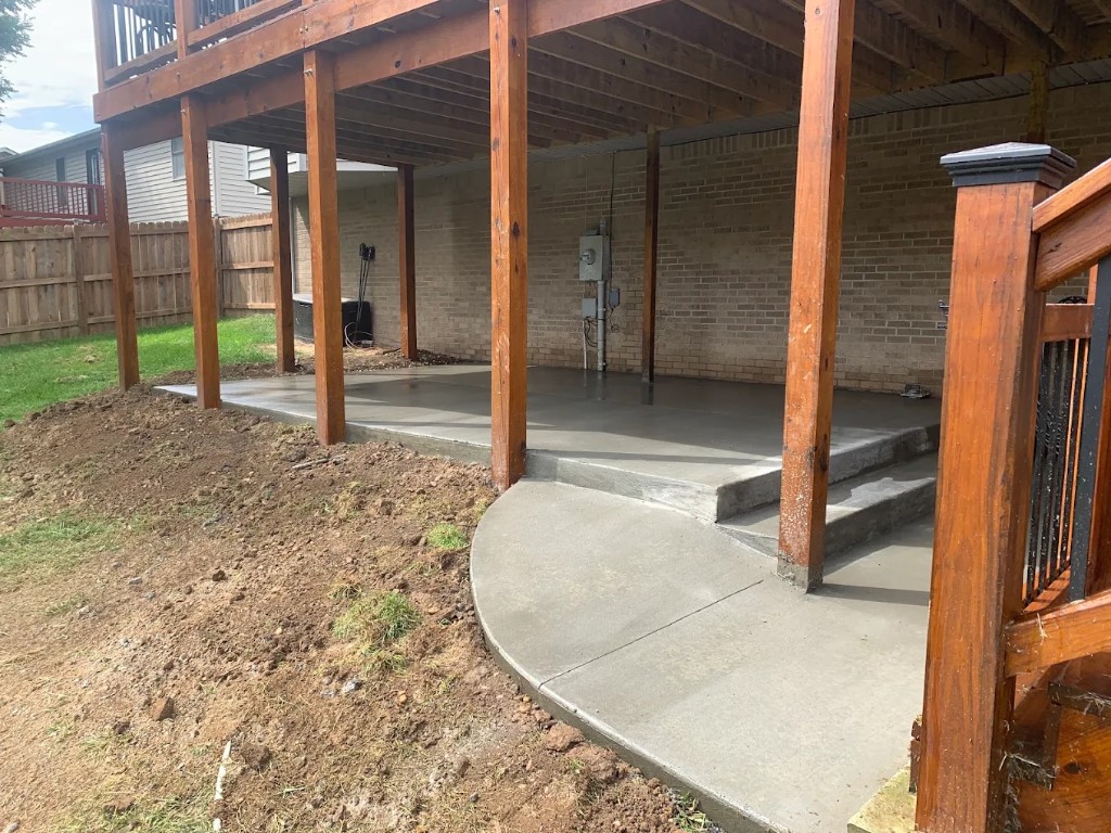 Concrete pad, step, and curved landing poured under a wood deck